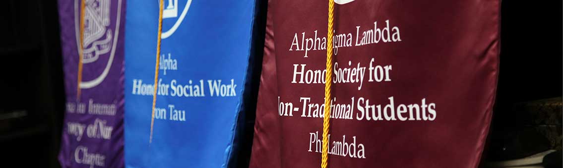 honor society standards displayed at Thomas University commencement